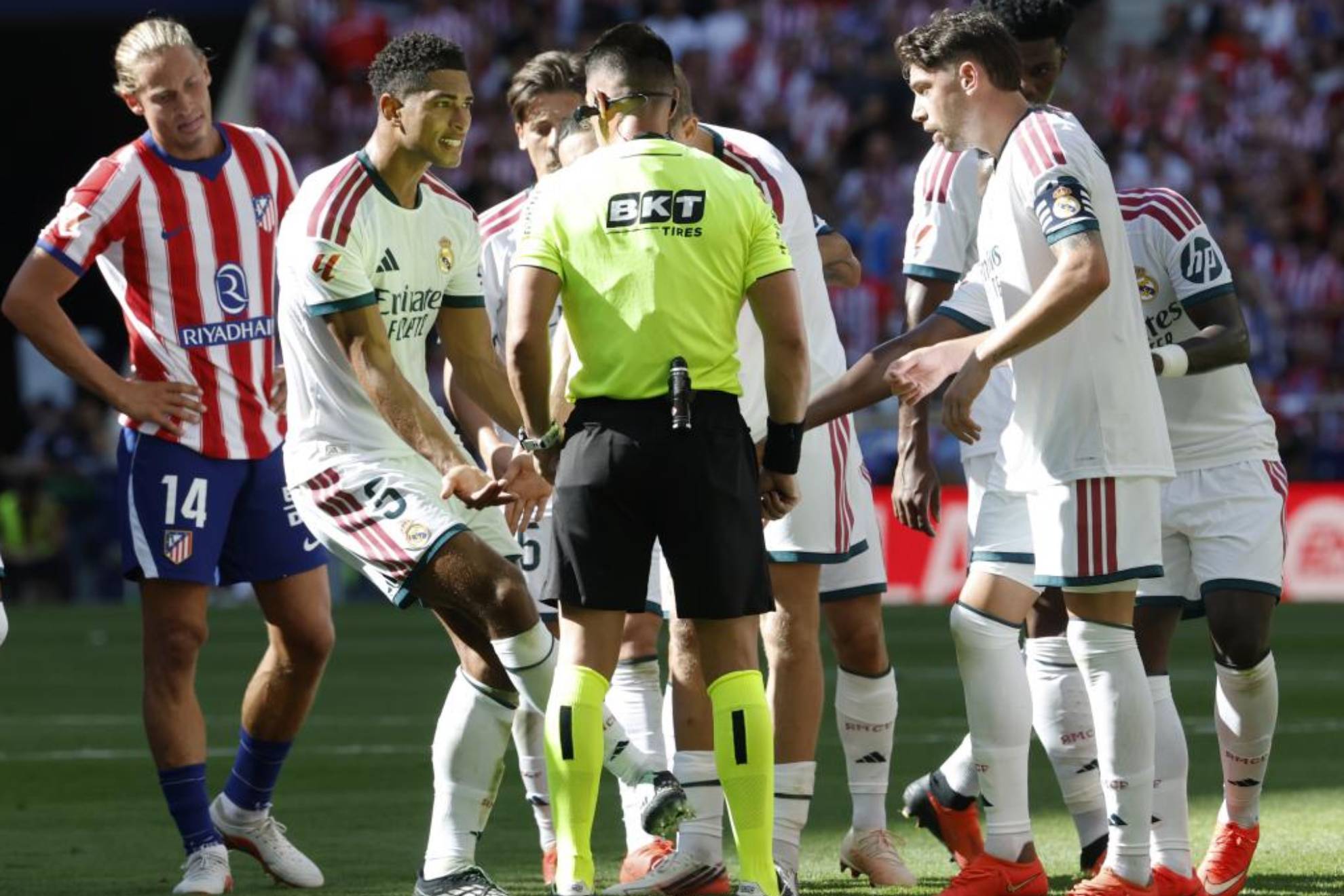 Los jugadores del Real Madrid protestan al árbitro en el derbi. CHEMA REY