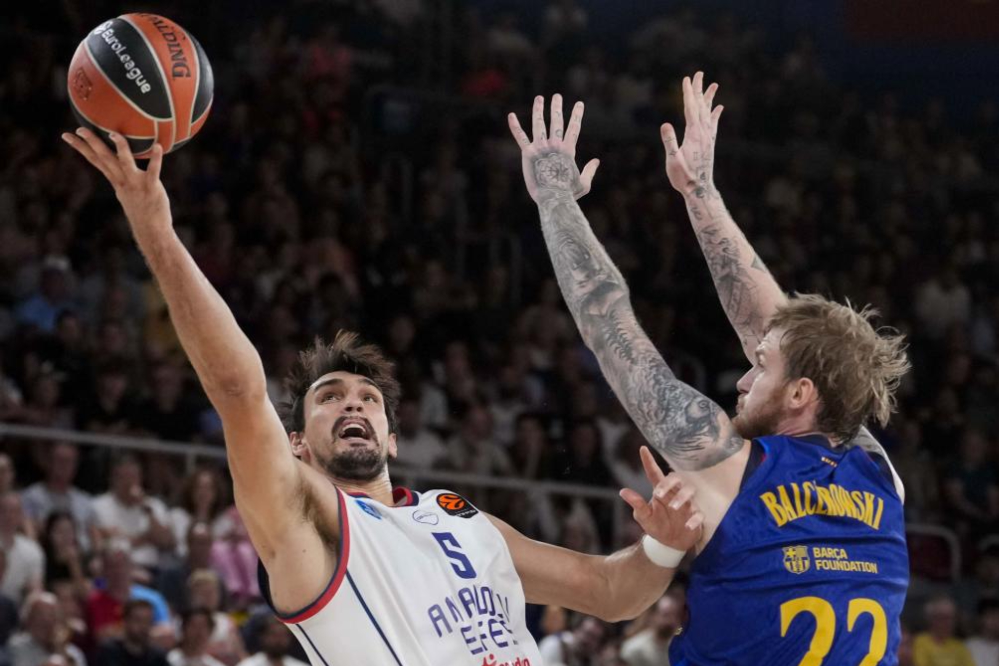 Dario Saric entra a canasta defendido por el polaco Olek Balcerowski. EFE.