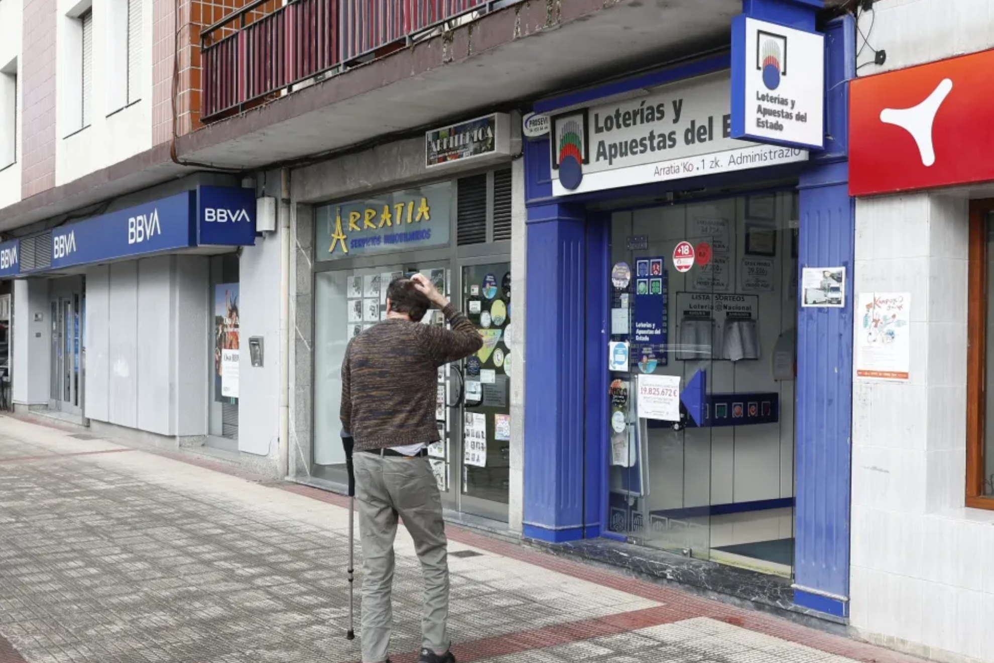 Hombre en la puerta de una administración de lotería EFE