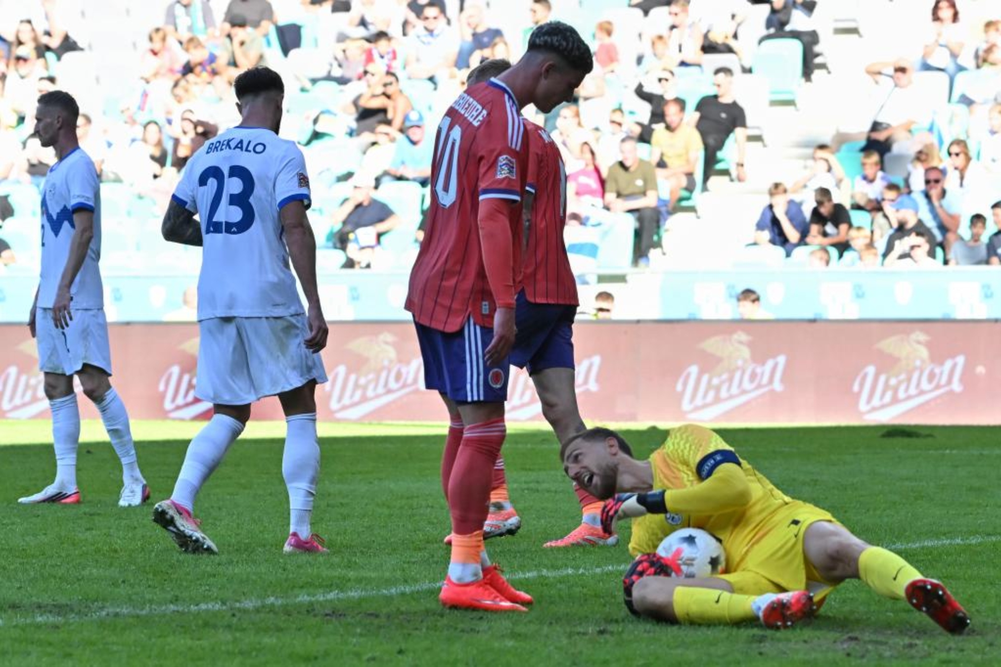 Jan Oblak detiene un balón en presencia de Robbie Ure.