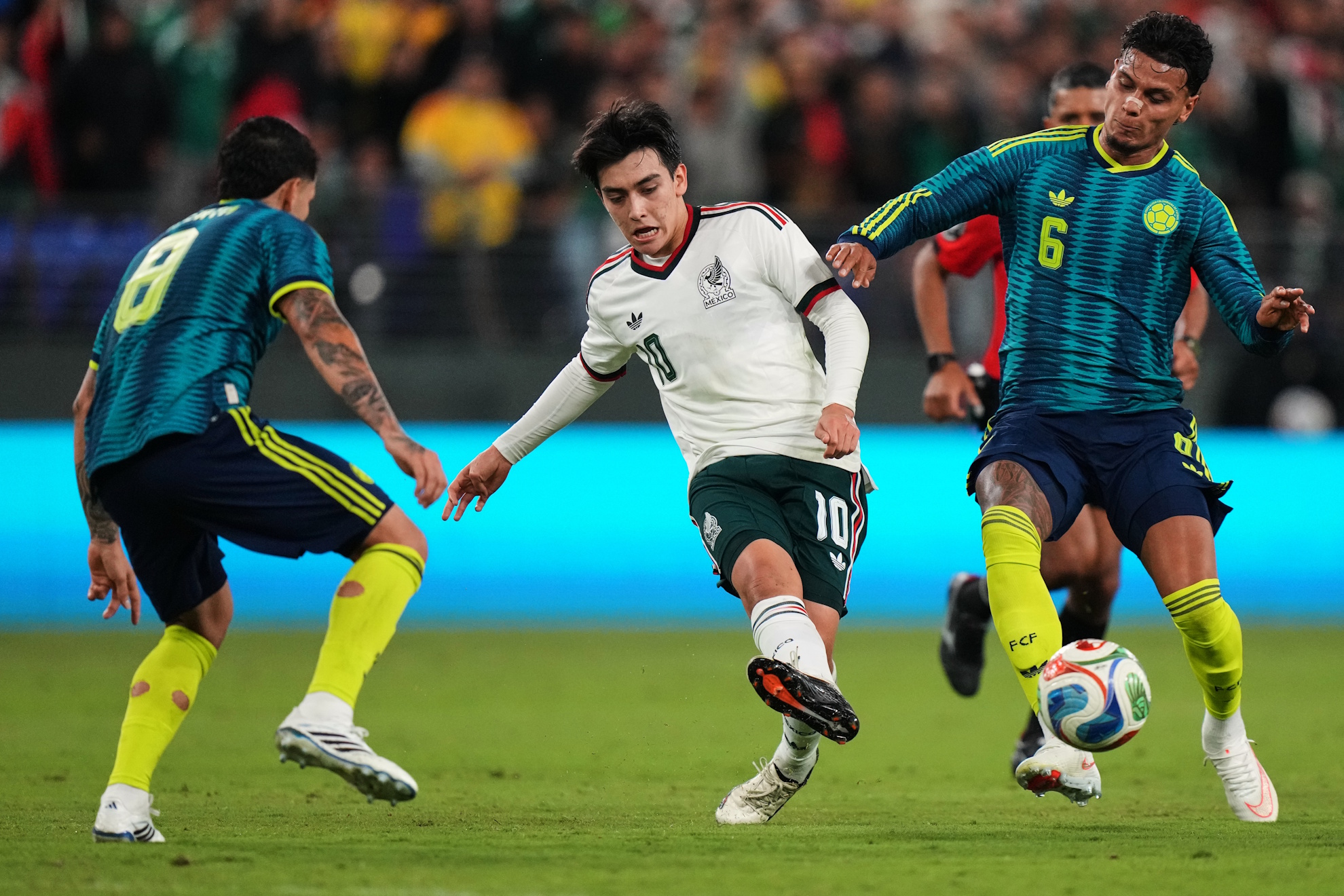 Mexico's Gilberto Mora (10) kicks the ball against Colombia's Gustavo Puerta (8) and Richard Rios (6) during the first half of an international friendly soccer match, Saturday, Sept. 26, 2026, in Baltimore. (AP Photo/Stephanie Scarbrough)