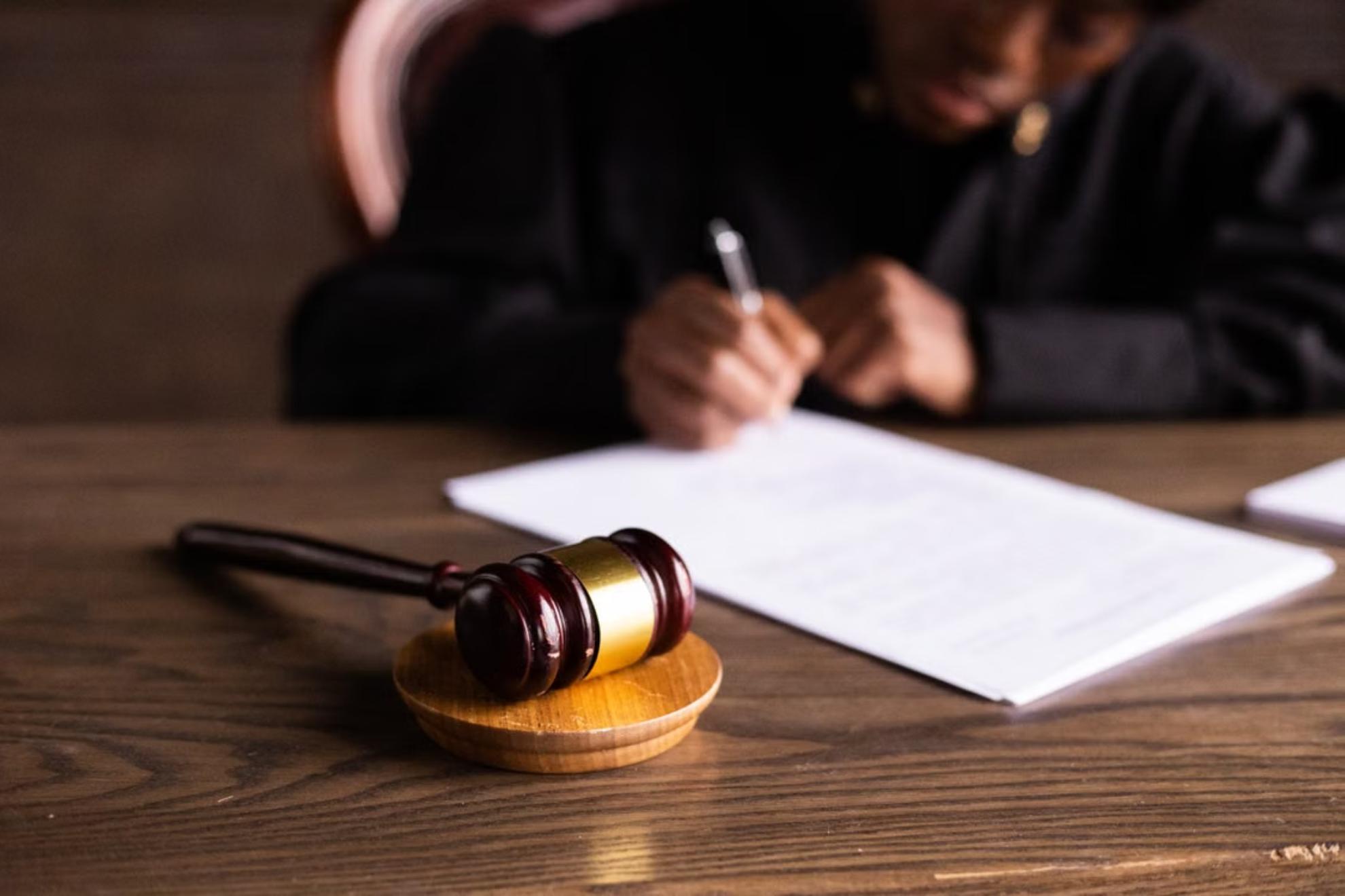 Imagen de un juez firmando documentos. PEXELS