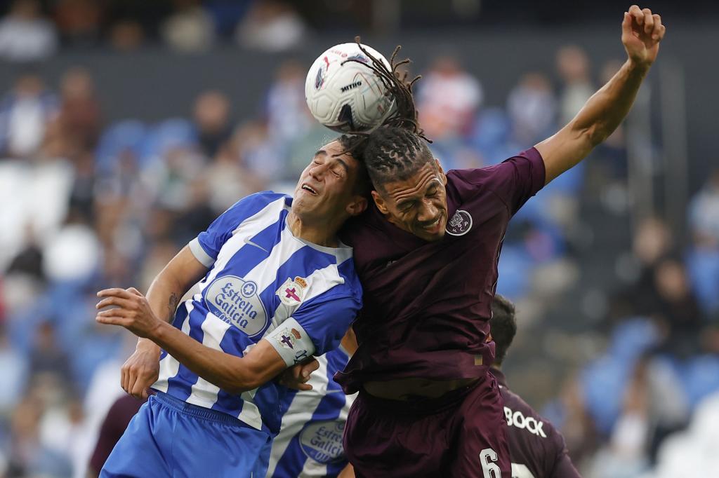 Diego Villares (i), disputa el balón ante el jugador del Oporto, Chris Smalling, durante el encuentro amistoso que disputan este viernes en el estadio de Riazor en A Coruña. EFE/Cabalar