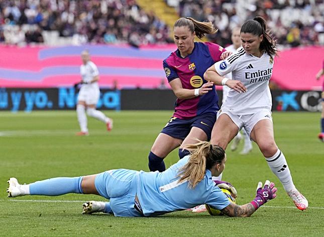 La portera del FC Barcelona Cata Coll atrapa el balón ante Signe Bruun, dcha, del Real Madrid, durante el partido de Liga Femenina disputado este domingo en el Estadi Olímpic Lluís Companys. EFE