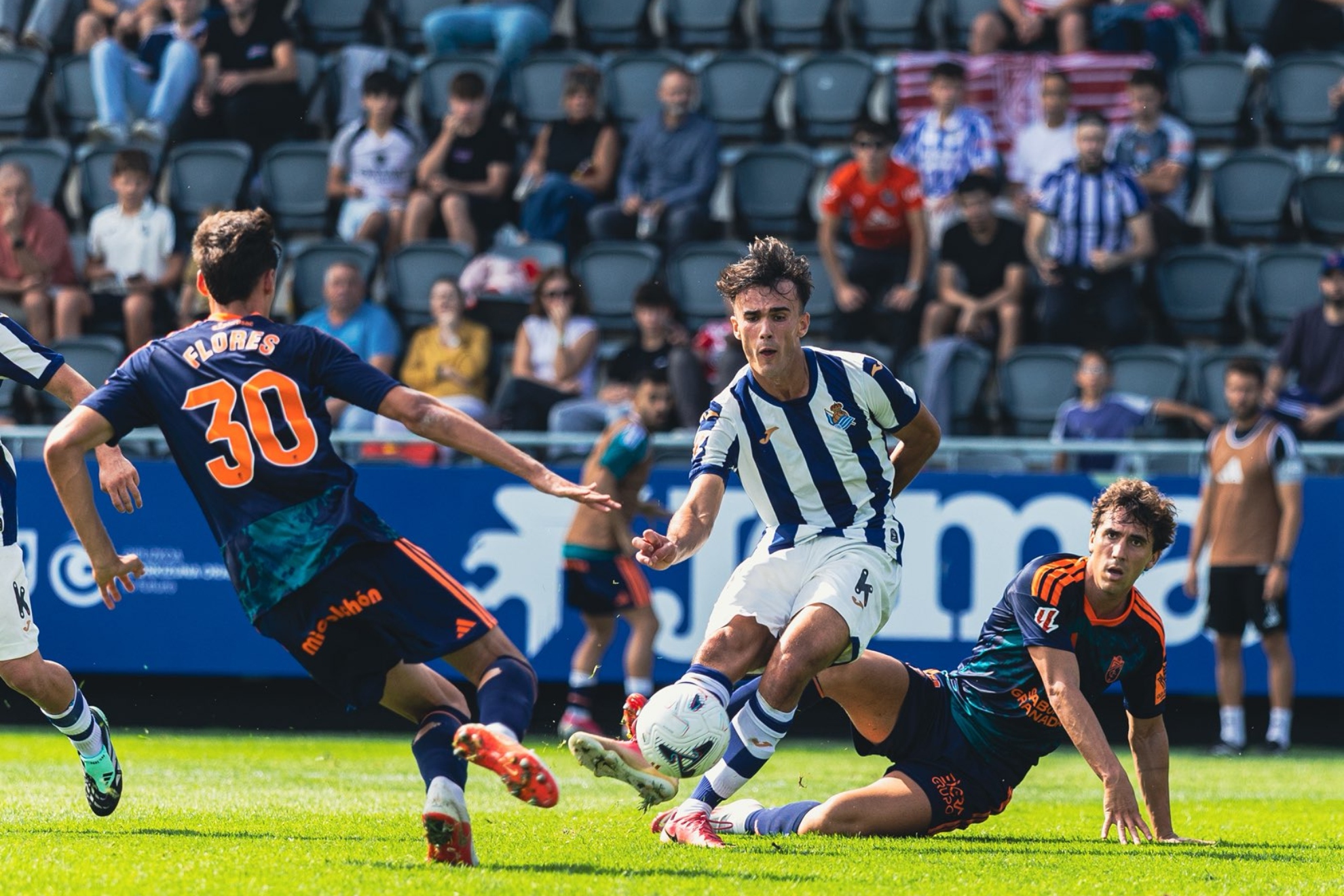 Gorka Carrera remata a gol contra el Granada en Zubieta, con mucho asiento vacío.
