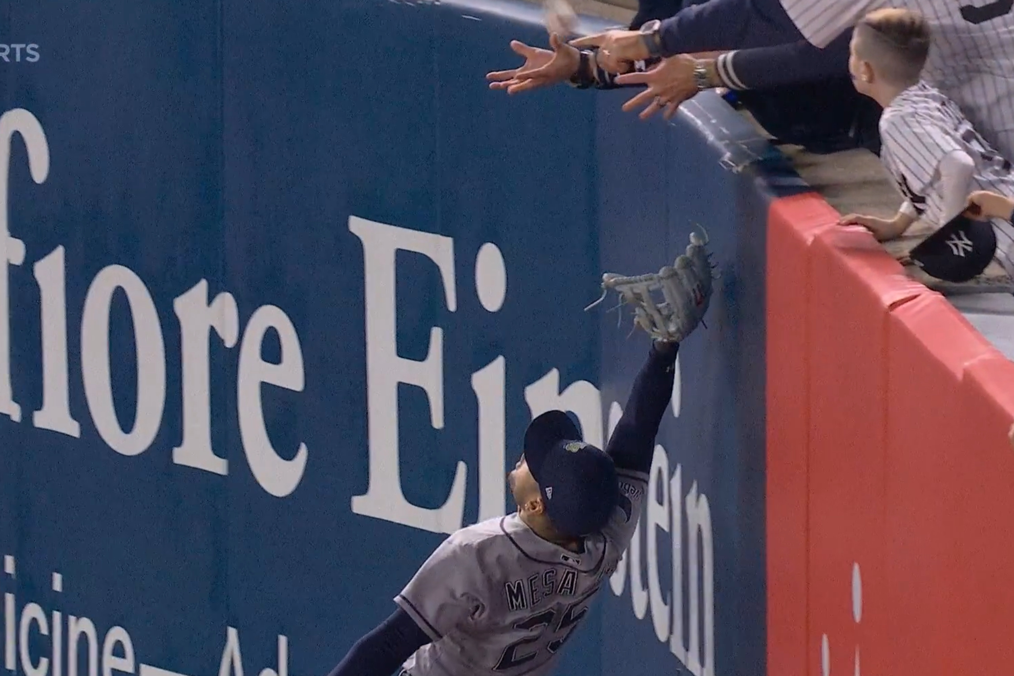Momento exacto en el que un aficionado de los Yankee atrapa la pelota.
