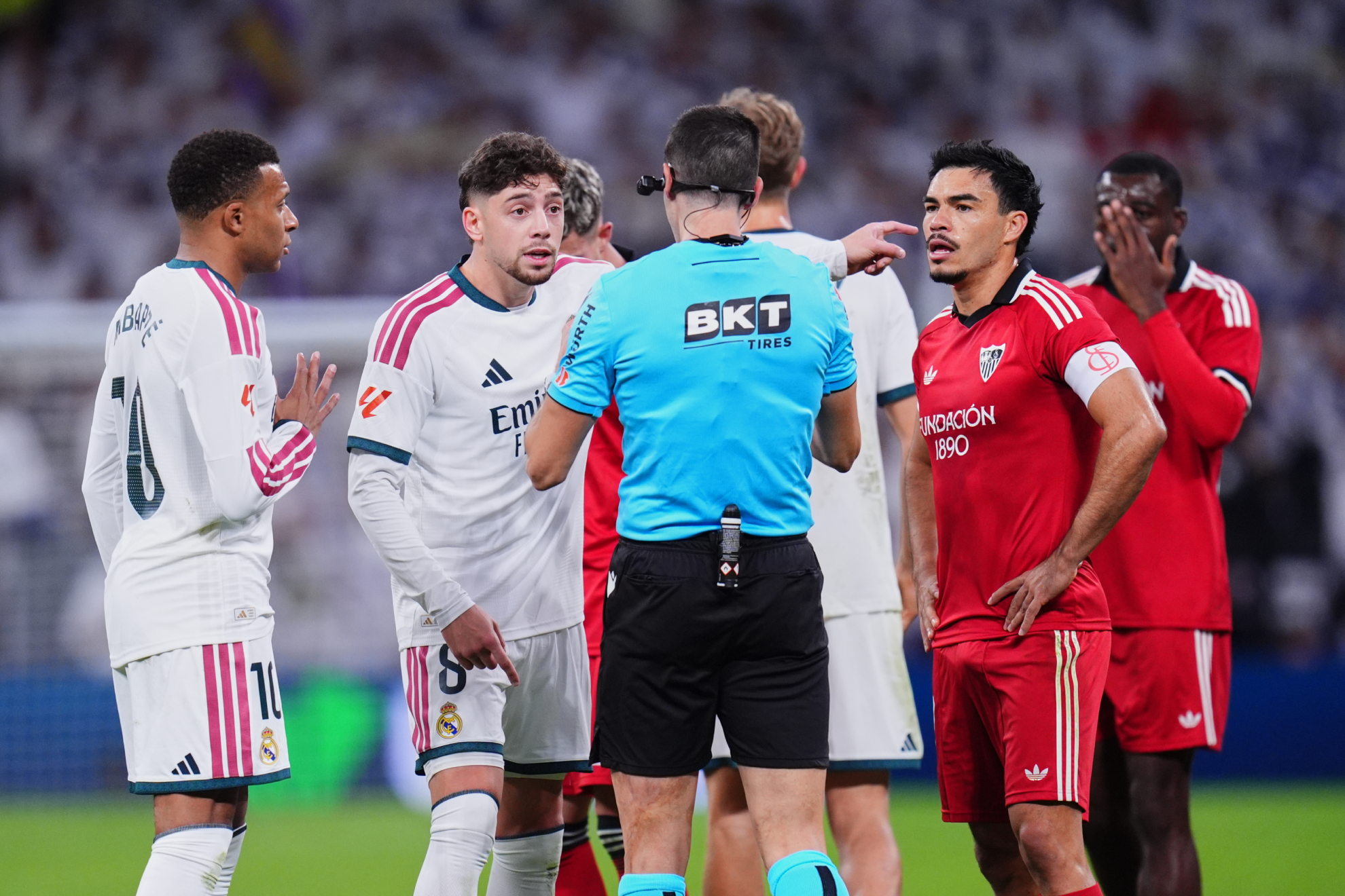 Jugadores del Real Madrid y el Sevilla teniendo la fortuna de conversar con un árbitro español. LAPRESSE