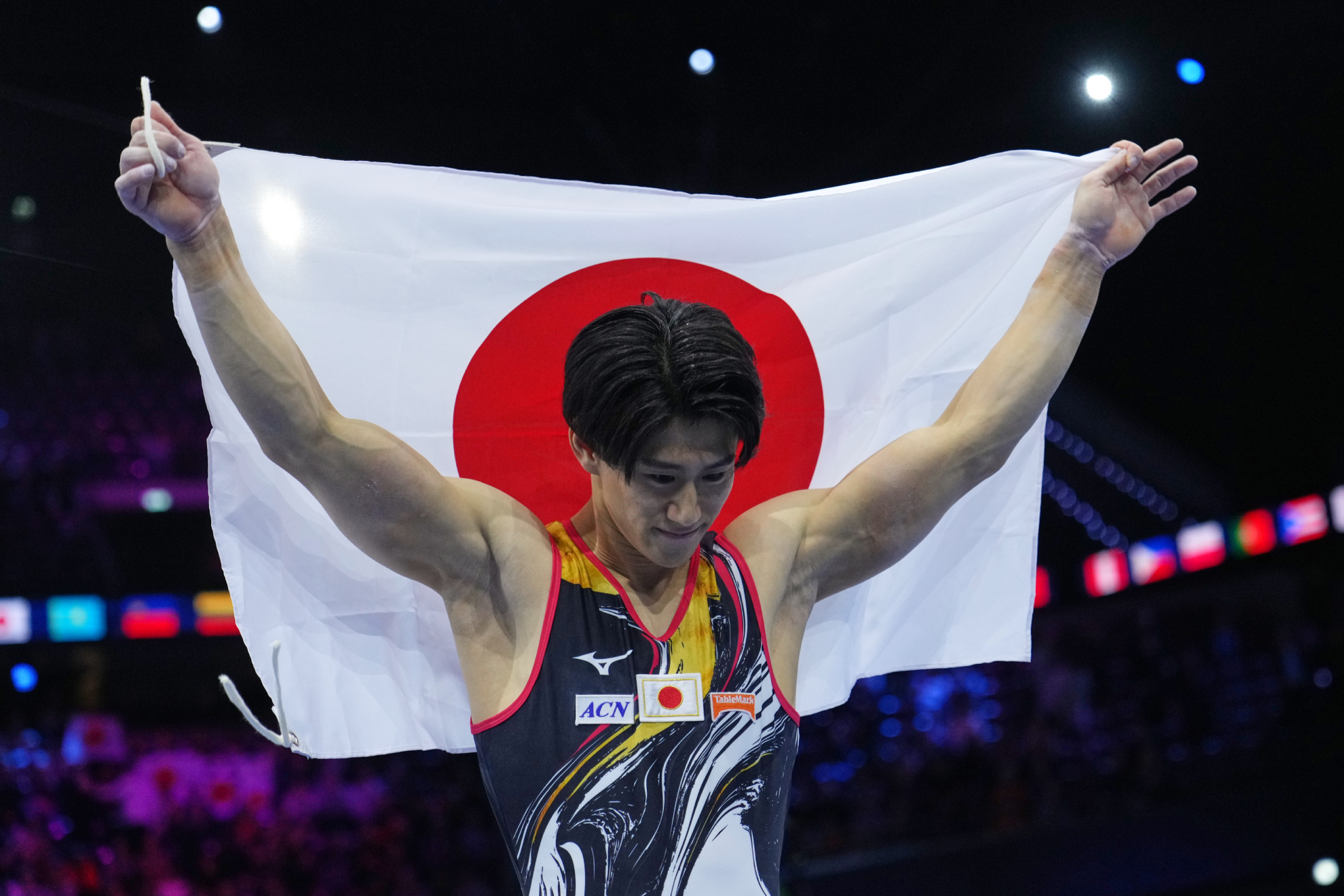 Daiki Hashimoto con la bandera de Japón tras lograr el oro en el concurso completo del Mundial de Rotterdam. LAPRESSE