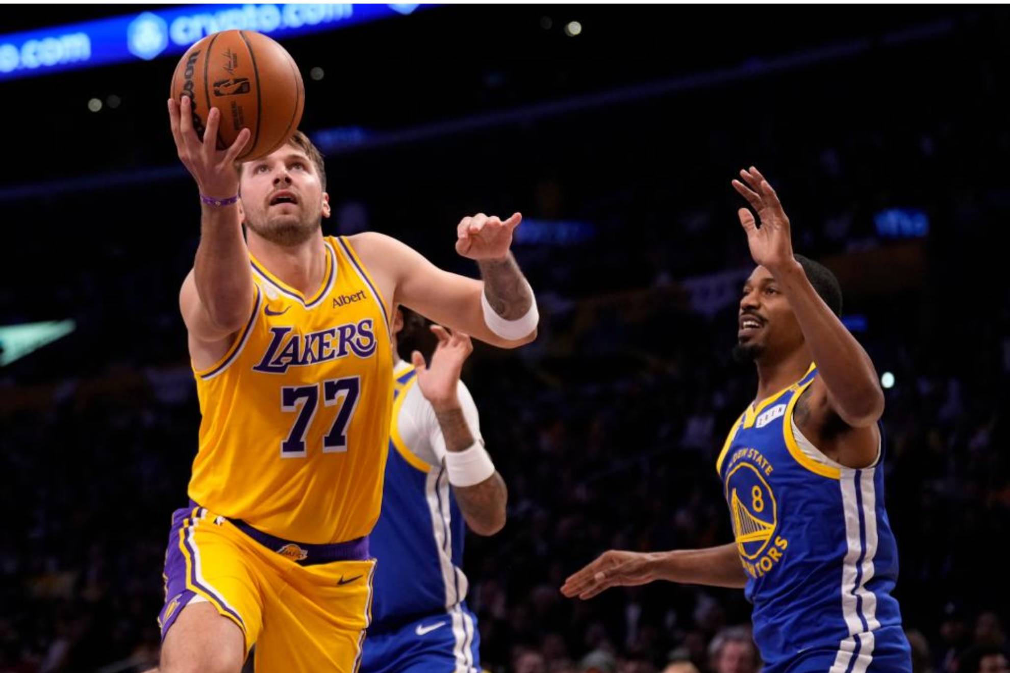 Luka Doncic hace una entrada a canasta tras superar a dos defensores de los Warriors. LAPRESSE
