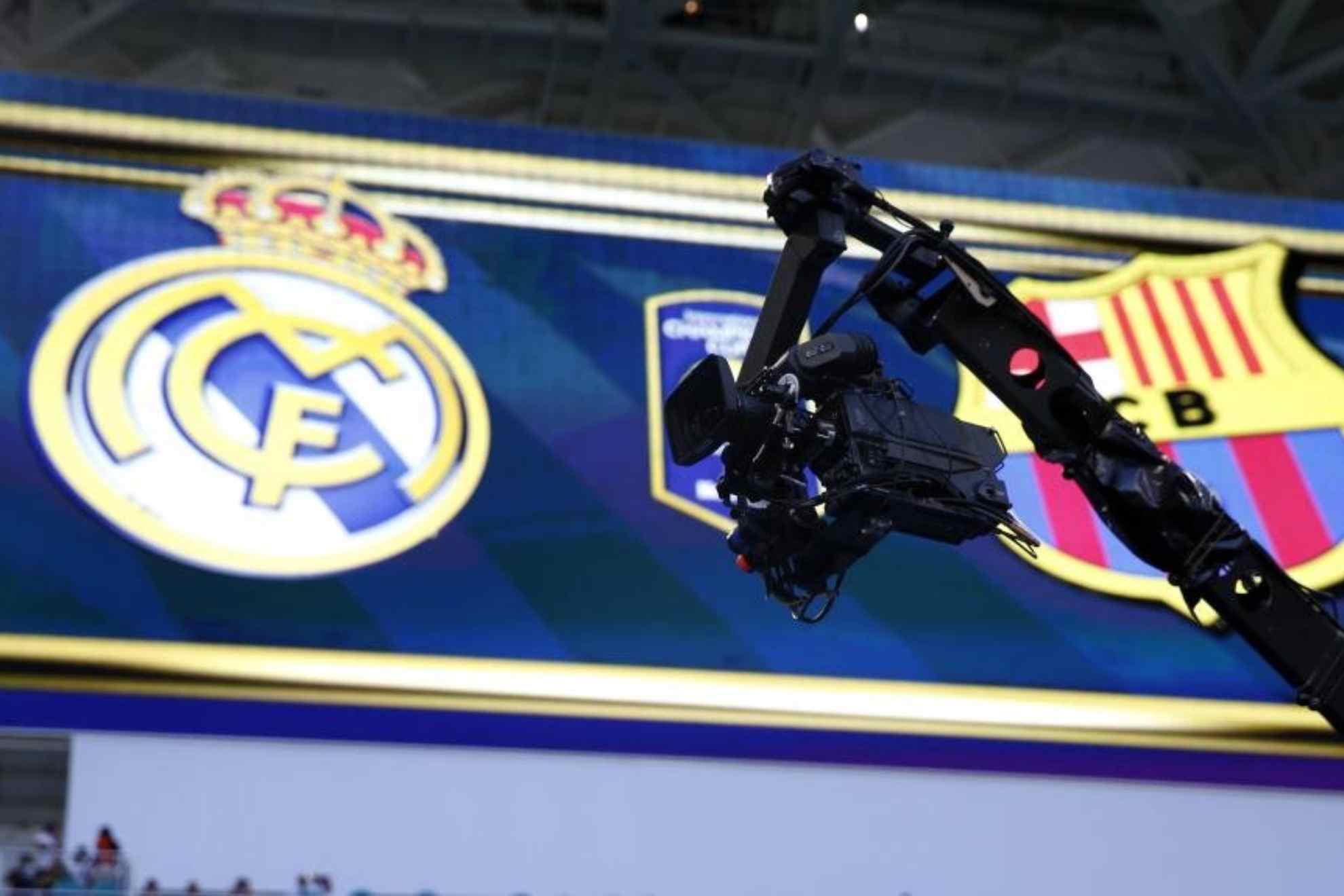 Una cámara de televisión con los escudos de Real Madrid y Barcelona en un partido entre ambos. CHEMA REY (MARCA)