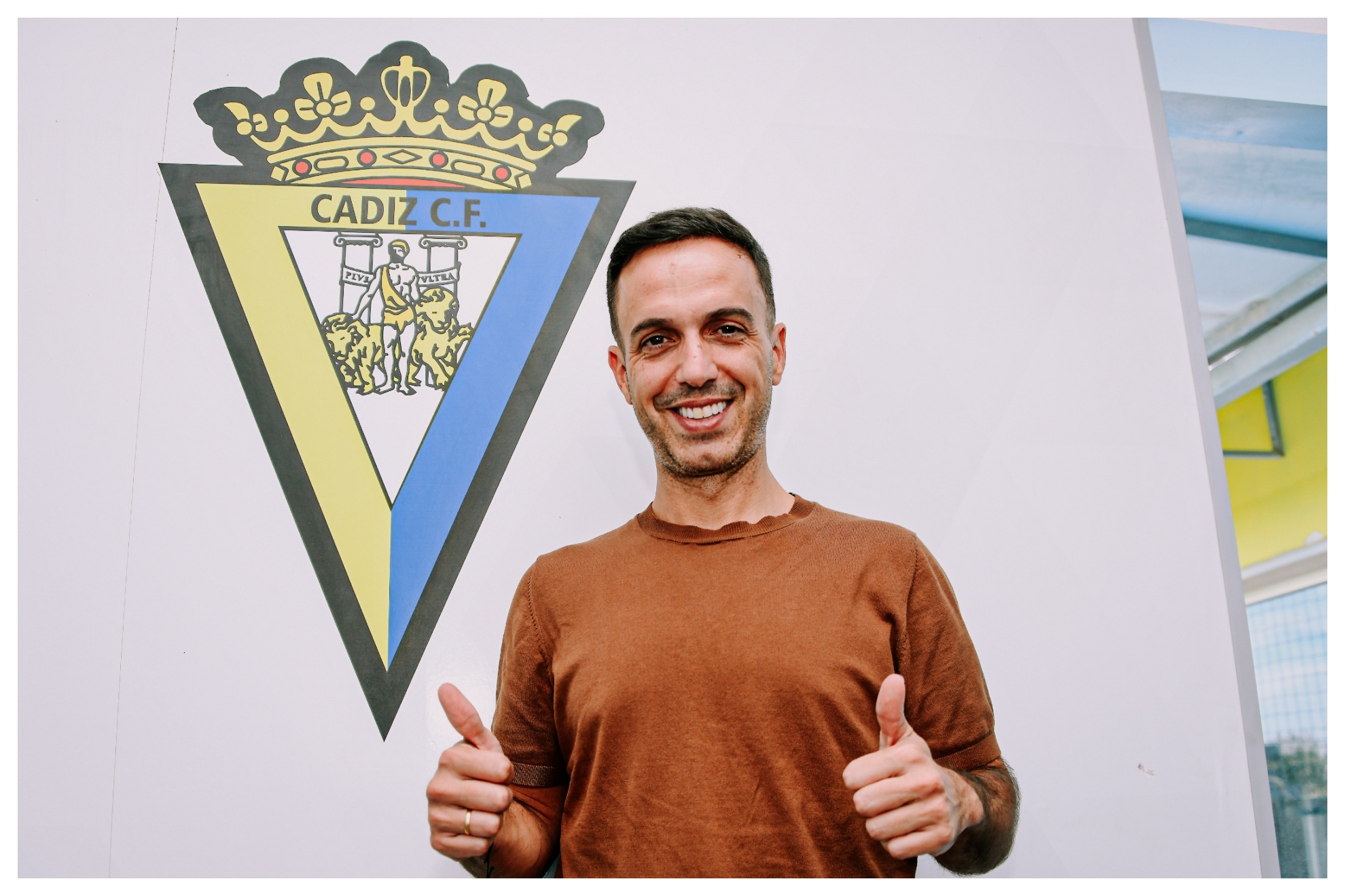 Borja Jiménez, posa delante del escudo de su nuevo club CÁDIZ CF