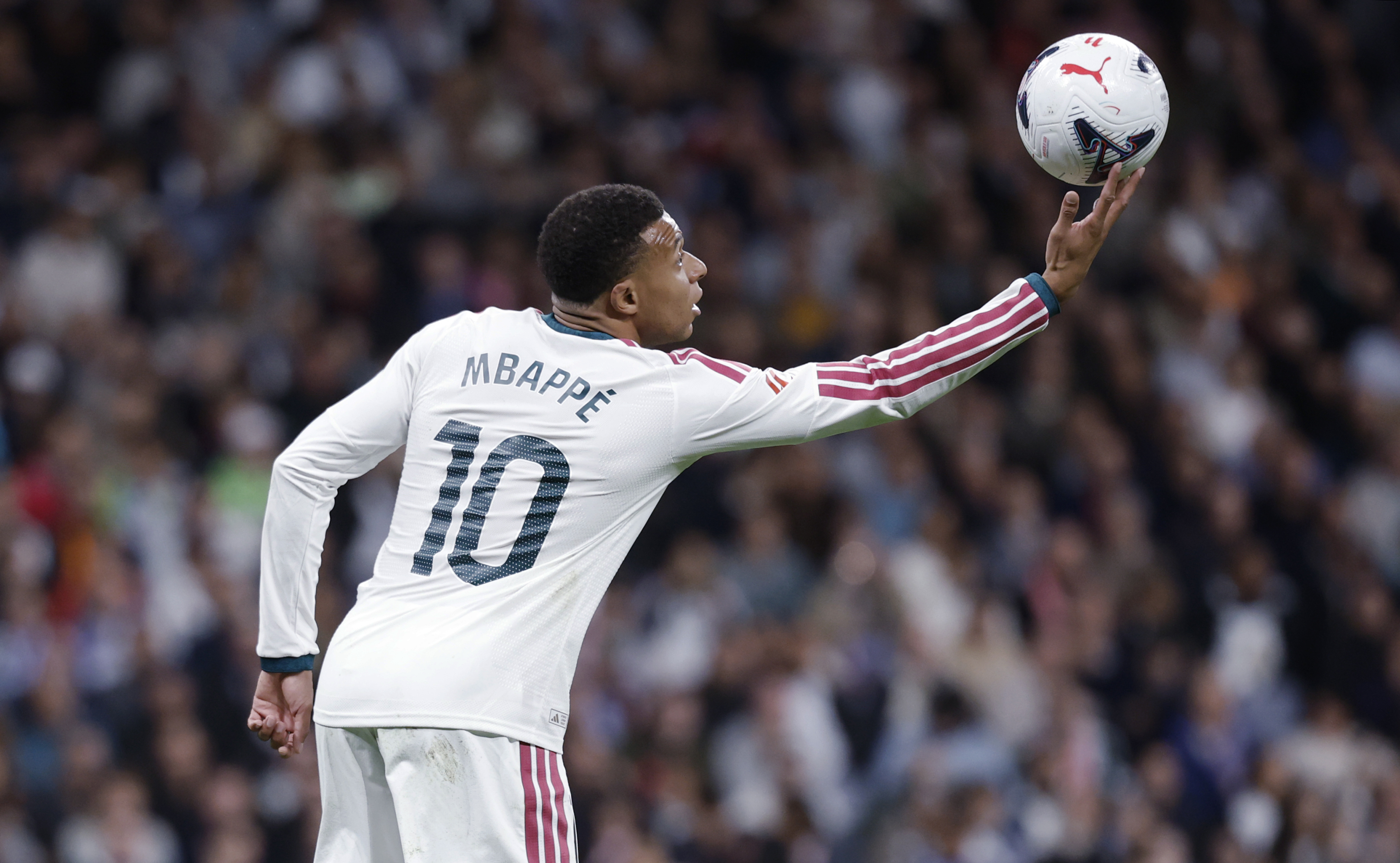 Kylian Mbappé intenta coger un balón que parece descontrolarse durante un partido del Real Madrid. Chema Rey